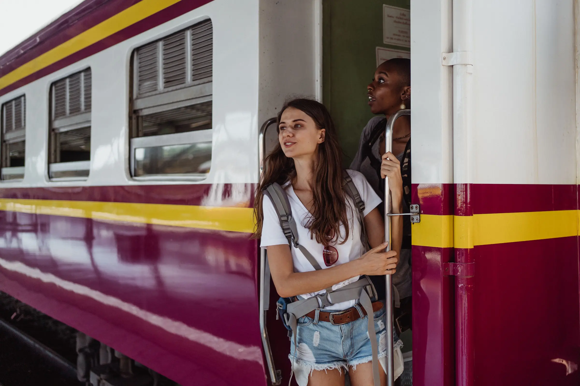 How to travel on a budget: backpacker looking out of a regional train window