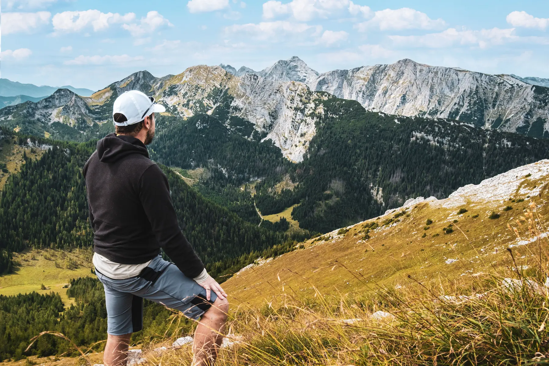 How to travel on a budget: backpacker resting at a free mountain viewpoint