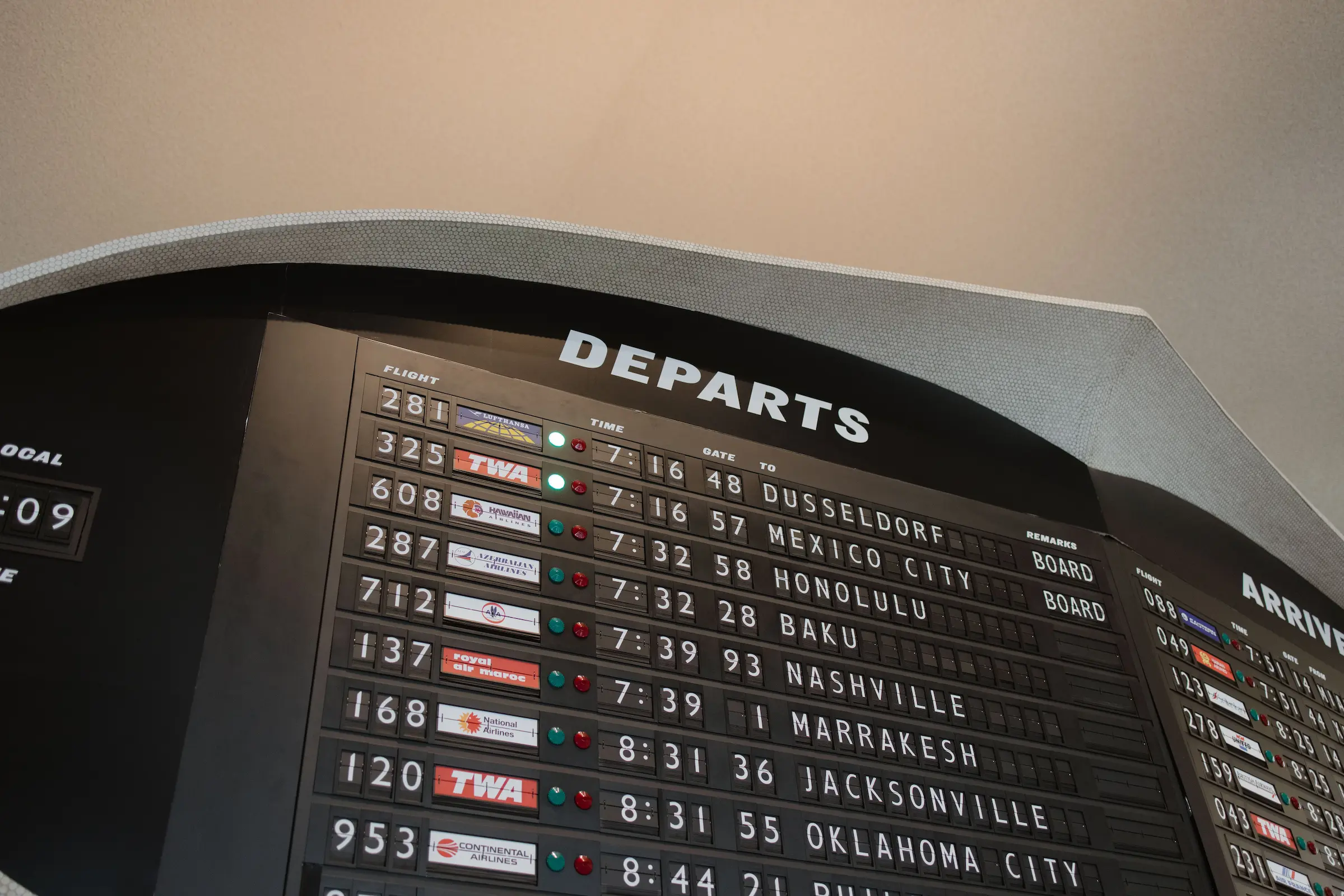 Backpacker checking an airport departures board on one of the cheapest days to fly