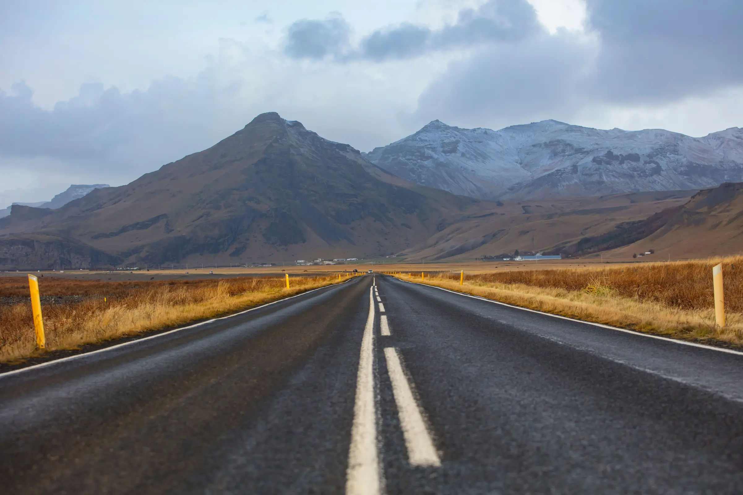 Iceland Ring Road itinerary 7 days: campervan on Route 1 below green cliffs in South Iceland